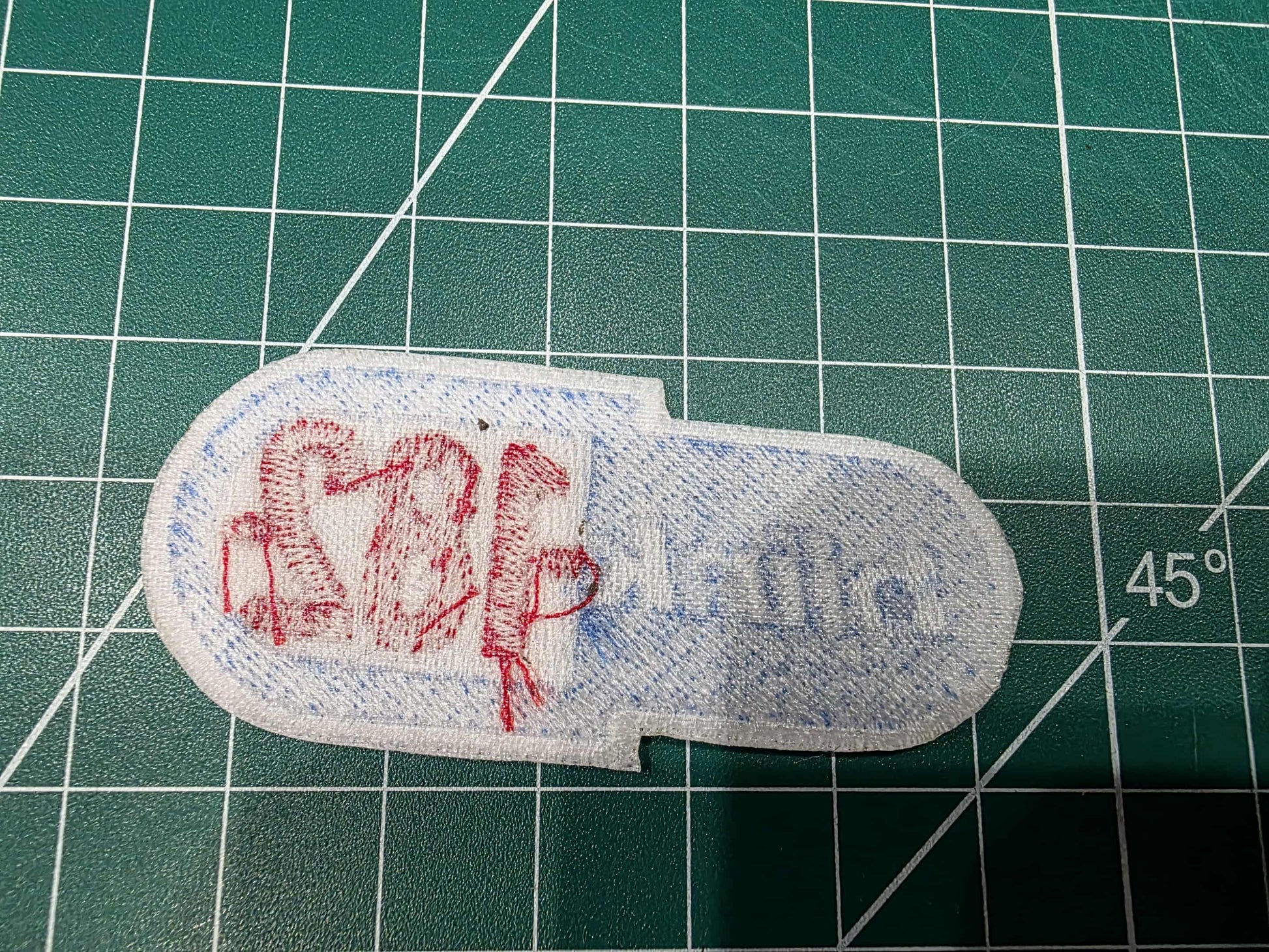 Fabric patch with text on a green cutting mat